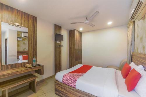 een hotelkamer met een bed en een spiegel bij Serenity Inn in Chennai