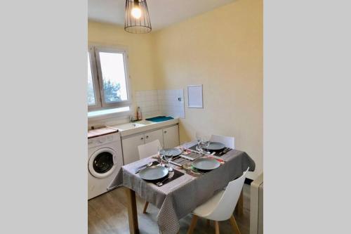 une cuisine avec une table et une machine à laver dans l'établissement Appart T2 Gare TGV spacieux et tout équipé, au Mans