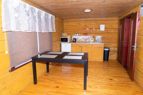 a black table in a room with a kitchen at "Čiekuri" in Aglona