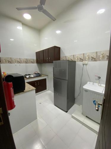 a small kitchen with a refrigerator and a sink at RED-20 - Tag Salalah in Salalah