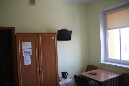 Habitación con armario y TV en la pared. en OSiR w Człuchowie, en Czluchów