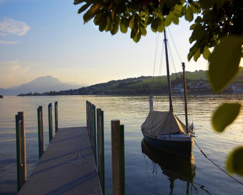 a boat tied to a dock on a lake at Hotel Restaurant Seehof in Küssnacht