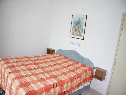 1 dormitorio con 1 cama y una foto en la pared en Apartments Lovran en Lovran