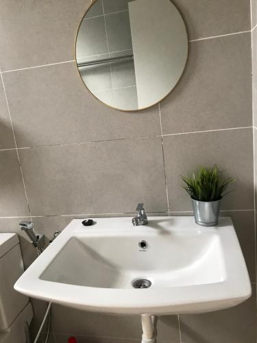 a bathroom with a white sink and a mirror at 75 Cozy Home - Homestay Kluang (Gated and Guarded, Northern European Interior) in Kluang