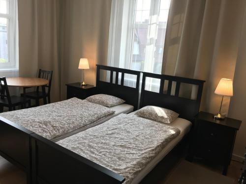 2 camas en un dormitorio con 2 lámparas y una ventana en Belgard- House 32, en Białogard