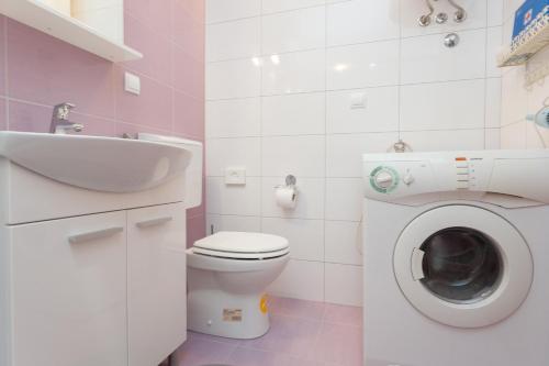 ein Badezimmer mit einer Waschmaschine und einem Waschbecken in der Unterkunft Studio and Room Lena in Dubrovnik
