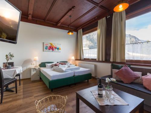 a hotel room with a bed and a couch and a table at Gasthof Restaurant Waldcafé in Mayrhofen