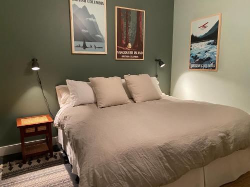 uma cama num quarto com dois cartazes na parede em Meadowbrook Guest Suite em Brentwood Bay