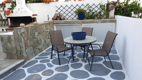 a patio with a table and chairs and a fireplace at Galazio Kyma in Agios Ioannis