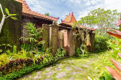 an old house with a garden in front of it at Tirta Jenar Villas by GenuineHost in Tegalalang