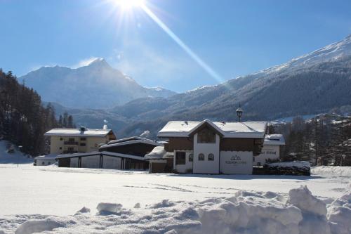 a house in the snow with a mountain in the background at Vizensn Living in Sölden