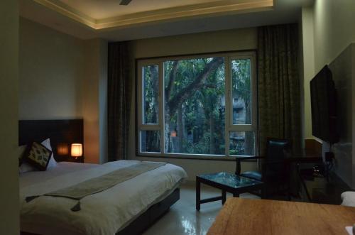 een hotelkamer met een bed en een groot raam bij Hotel Sopan Heights in New Delhi