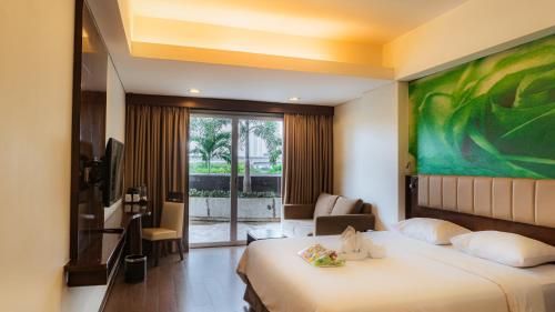 una habitación de hotel con una cama y una gran pintura en la pared en PrimeBiz Cikarang, en Cikarang