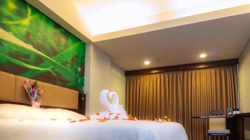 a bedroom with a bed with a large painting on the wall at PrimeBiz Cikarang in Cikarang