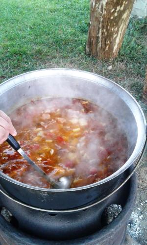 a pot of food with a person stirring it at Shum Cheremosha in Verkhovyna