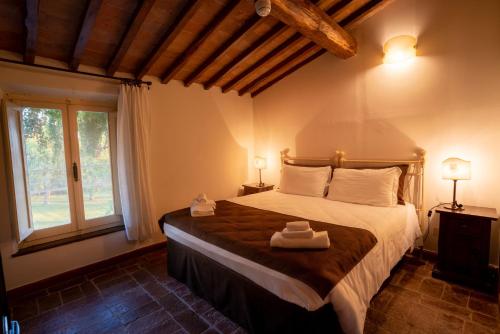 a bedroom with a bed with two towels on it at Borgo San Lorenzo a Linari in San Rocco a Pilli