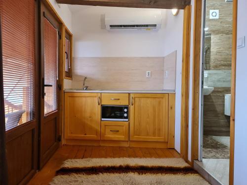a small kitchen with wooden cabinets and a sink at Mamin Kolio in Bansko
