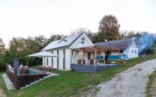 a white house with a swimming pool and a house at GORIČKE IŽE in Križevci