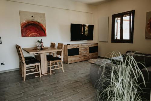 sala de estar con mesa y TV en Sivota Luxury Apartments en Sivota