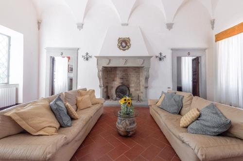 a living room with two couches and a fireplace at Borgo San Lorenzo a Linari in San Rocco a Pilli