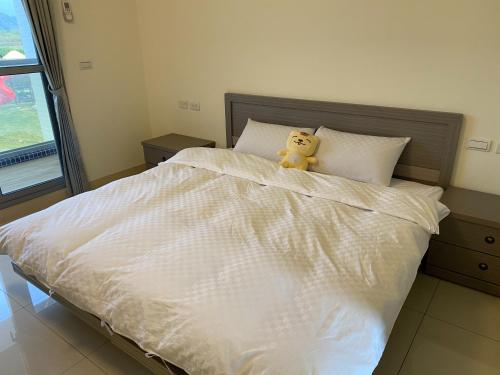 a teddy bear sitting on top of a bed at 枋山六號 in Fangshan