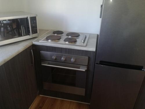 uma cozinha com um fogão e um micro-ondas em Gansbaai Self-Catering Apartment em Gansbaai