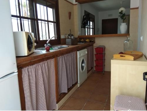 a kitchen with a sink and a washing machine at El Rincón de Bolonia in Bolonia