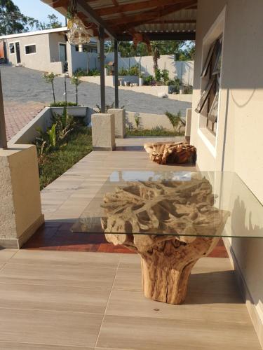 a glass table with a log on top of it at Goggas Nest BNB & Restaurant in Matsapha