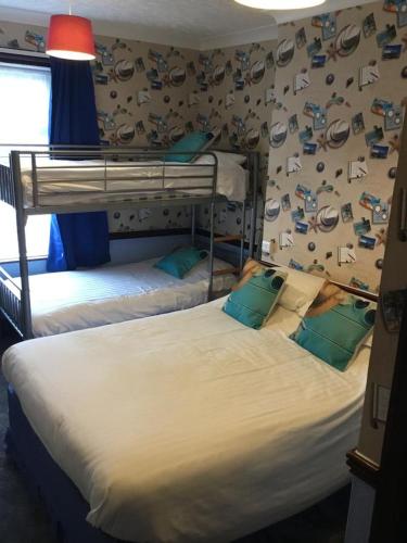 two bunk beds in a room with a wall covered in stickers at Valdene Hotel in Blackpool
