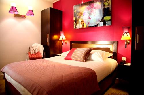 a bedroom with a large bed with red walls at Hotel Best Western Anjou Lafayette in Paris