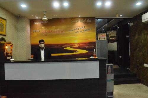 a man with a beard sitting at a bar in a building at Hotel Sopan Heights in New Delhi