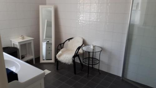 a bathroom with a chair and a table and a mirror at Stenungsögården in Stenungsund