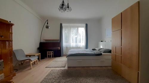 a bedroom with a bed and a desk and a window at Kamocsay Vendégház in Mór