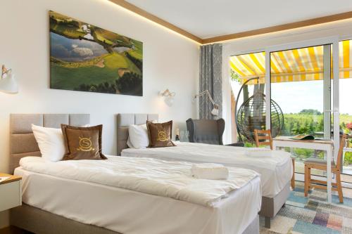 um quarto de hotel com duas camas e uma varanda em Bungalows at Sierra Golf Resort em Wejherowo