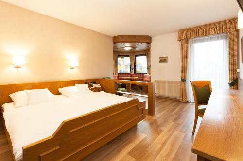 sypialnia z łóżkiem, biurkiem i stołem w obiekcie Landgasthof Hotel Hirsch w mieście Loßburg