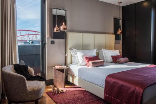 um quarto de hotel com uma cama e uma cadeira em Upon Lisbon Prime Residences em Lisboa