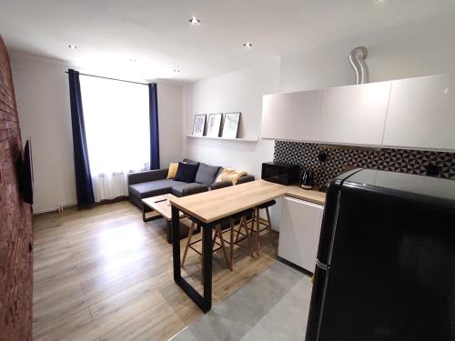 a kitchen and living room with a table and a couch at Mirror Apartments in Oświęcim