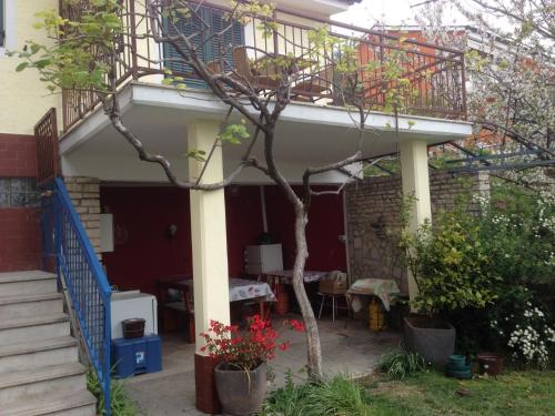 a house with a balcony and a table in a yard at Apartments and Rooms Knez in Portorož
