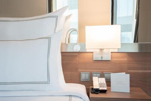 a hotel room with a bed and a phone on a table at Swissotel Bangkok Ratchada in Bangkok