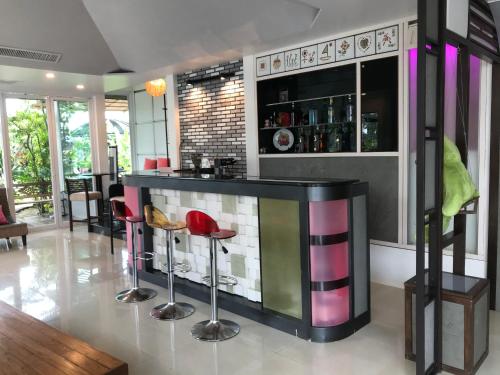 - un bar avec tabourets colorés dans une pièce dans l'établissement Cafe'@luv22, à Phuket
