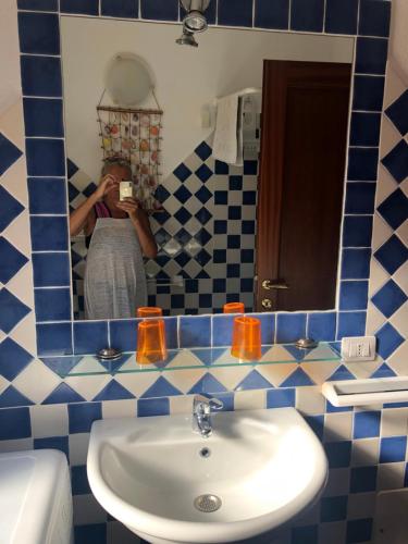 une femme prenant une photo d'un miroir de salle de bains dans l'établissement Tiffany 2, à Palau