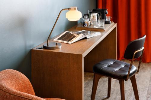 a desk with a lamp and a chair at Ours Blanc Hotel & Spa in Les Menuires