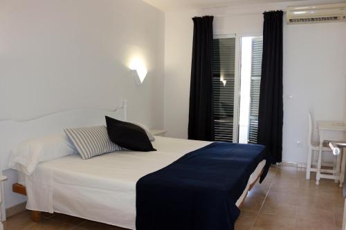 a bedroom with a bed with a laptop on it at Apartamentos Saura in Cala en Blanes