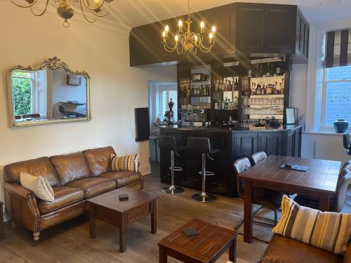 uma sala de estar com um sofá e um bar em Ebury Hotel Cottages and Apartment's em Canterbury