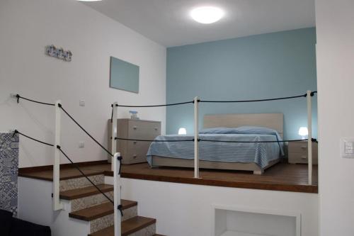 - une chambre avec un lit et des escaliers dans l'établissement Appartamento a pochi metri dal mare Nenia, à Balestrate