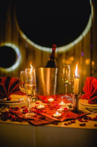 a table with two glasses of wine and a candle at Best Western Plus Tejvivaan in Visakhapatnam