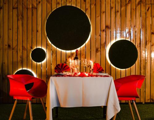 a table with red chairs and a white table with candles at Best Western Plus Tejvivaan in Visakhapatnam