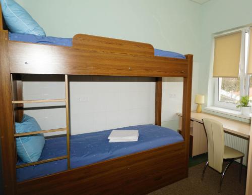 a bedroom with a bunk bed with a desk at City Hostel Panorama in Uzhhorod