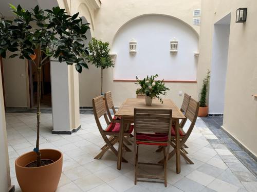 a dining room with a table and a potted tree at Casa de las Especias Hotel Boutique in Sanlúcar de Barrameda