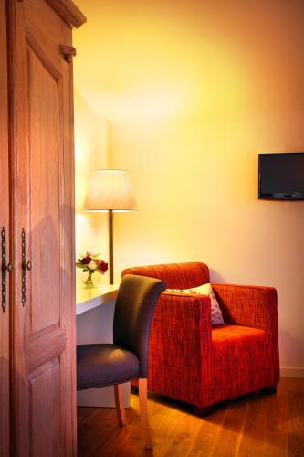 a living room with a red chair and a lamp at Hostería de Guara in Bierge